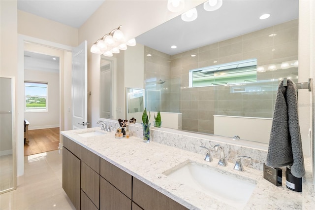 bathroom with tiled shower and vanity