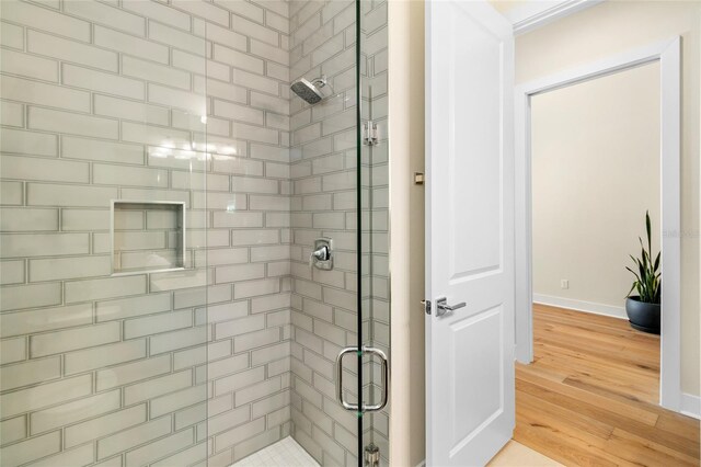 bathroom featuring hardwood / wood-style flooring and walk in shower