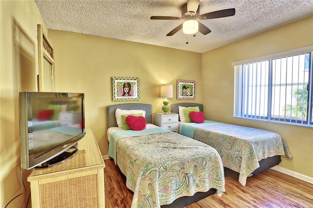 bedroom with hardwood / wood-style flooring, a textured ceiling, and ceiling fan