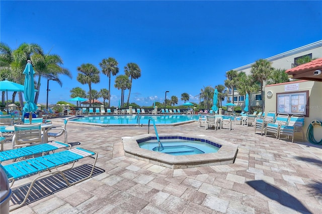 view of pool featuring a hot tub and a patio