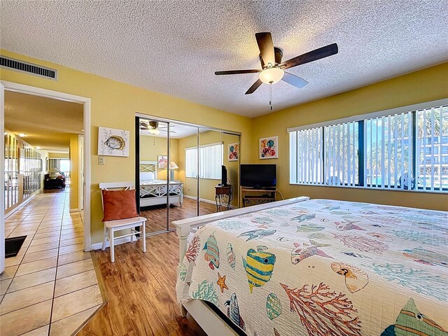 7532 Bayshore Dr Unit 205, Treasure Island, FL 33706 - bedroom with a closet, a textured ceiling, light wood-type flooring, ceiling fan, and baseboards