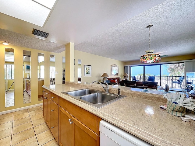 7532 Bayshore Dr Unit 205, Treasure Island, FL 33706 - kitchen with open floor plan, a sink, a textured ceiling, light countertops, and light tile patterned floors