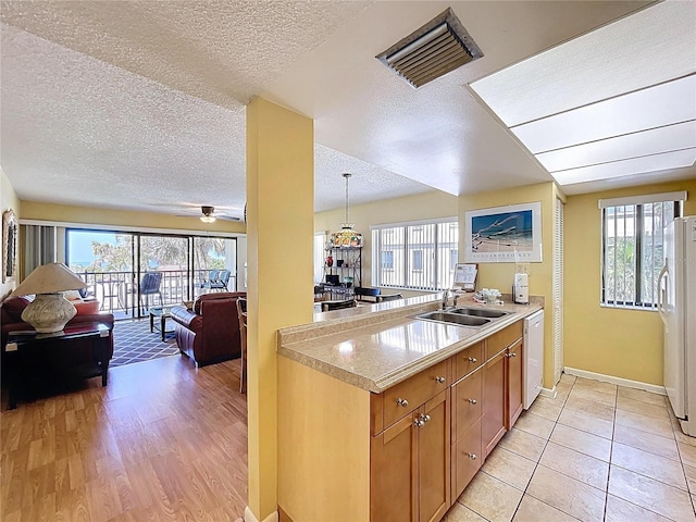 7532 Bayshore Dr Unit 205, Treasure Island, FL 33706 - kitchen featuring a sink, white appliances, a textured ceiling, open floor plan, and light countertops