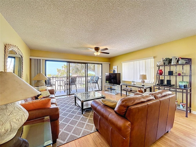 7532 Bayshore Dr Unit 205, Treasure Island, FL 33706 - living area with light wood finished floors, a textured ceiling, healthy amount of natural light, and ceiling fan