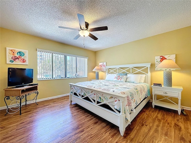 7532 Bayshore Dr Unit 205, Treasure Island, FL 33706 - bedroom with wood finished floors, baseboards, a textured ceiling, and ceiling fan