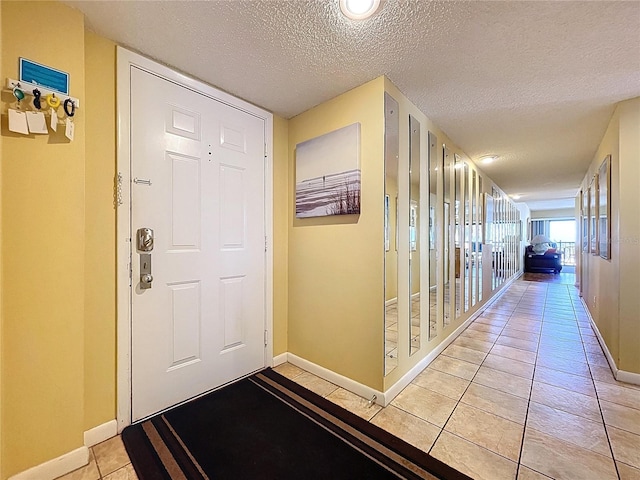 7532 Bayshore Dr Unit 205, Treasure Island, FL 33706 - hall featuring baseboards, a textured ceiling, and light tile patterned flooring