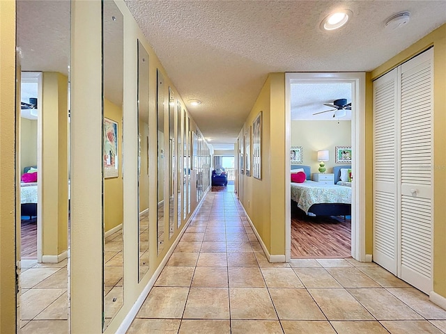7532 Bayshore Dr Unit 205, Treasure Island, FL 33706 - hall with light tile patterned floors, a textured ceiling, and baseboards