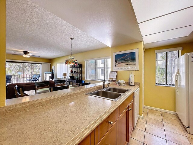 7532 Bayshore Dr Unit 205, Treasure Island, FL 33706 - kitchen featuring a sink, white appliances, brown cabinets, plenty of natural light, and a textured ceiling
