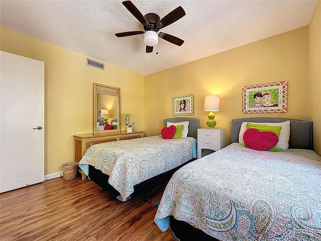 7532 Bayshore Dr Unit 205, Treasure Island, FL 33706 - bedroom with wood finished floors, a textured ceiling, a ceiling fan, and baseboards