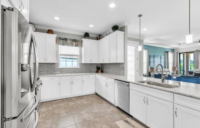 kitchen with white cabinetry, appliances with stainless steel finishes, sink, and decorative light fixtures