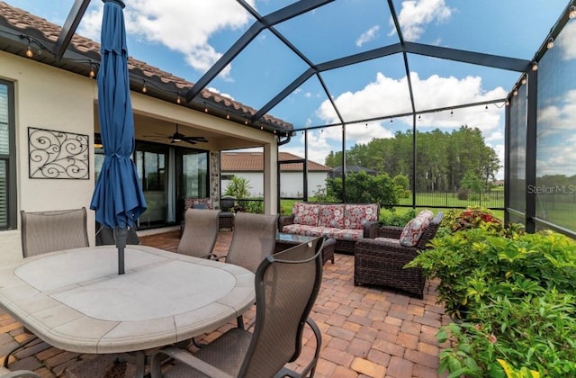 view of patio / terrace with an outdoor living space, a lanai, and ceiling fan