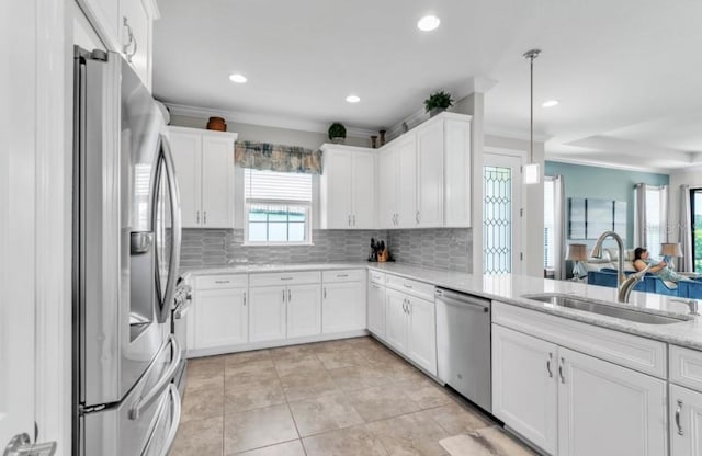 kitchen with white cabinetry, appliances with stainless steel finishes, sink, and decorative light fixtures