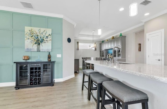 kitchen featuring crown molding, sink, decorative light fixtures, and green cabinetry