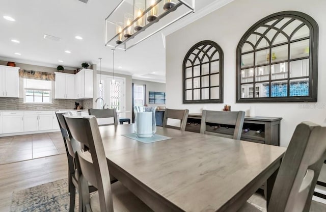 dining space featuring hardwood / wood-style flooring, ornamental molding, and a notable chandelier