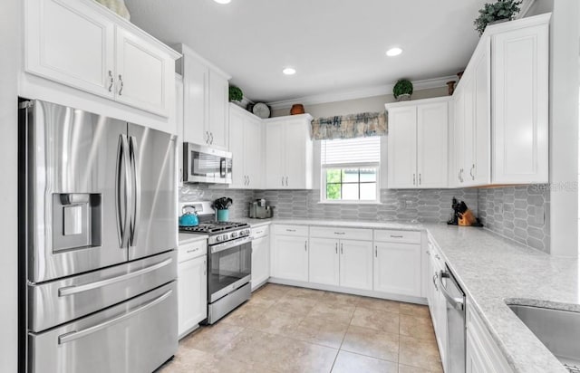 kitchen featuring white cabinetry, stainless steel appliances, and light stone counters