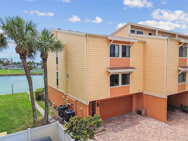 view of property exterior featuring a garage, central AC unit, and a water view