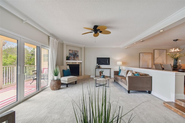 living room with ceiling fan, light colored carpet, a textured ceiling, and crown molding