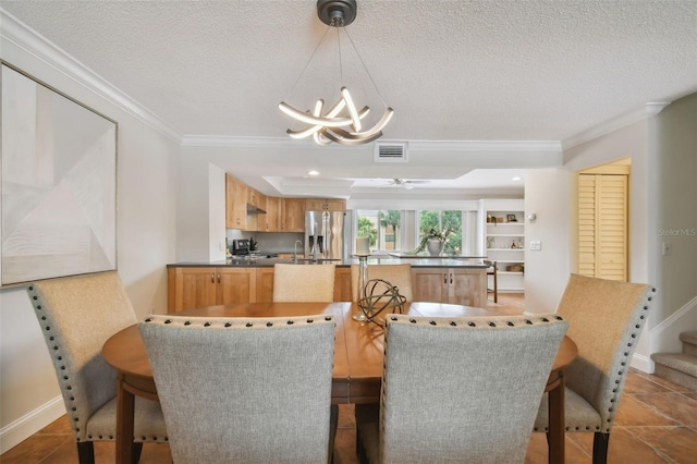 dining room featuring a chandelier, ornamental molding, and a textured ceiling