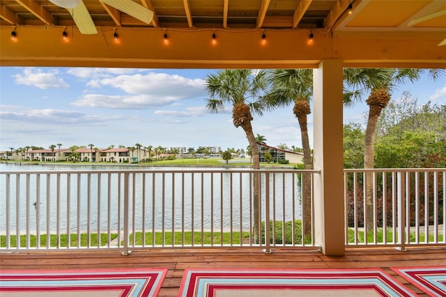 deck featuring ceiling fan and a water view