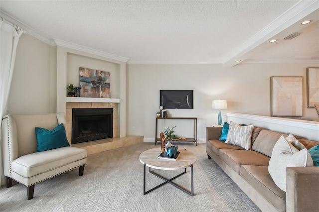 carpeted living room with a textured ceiling, ornamental molding, and a tiled fireplace