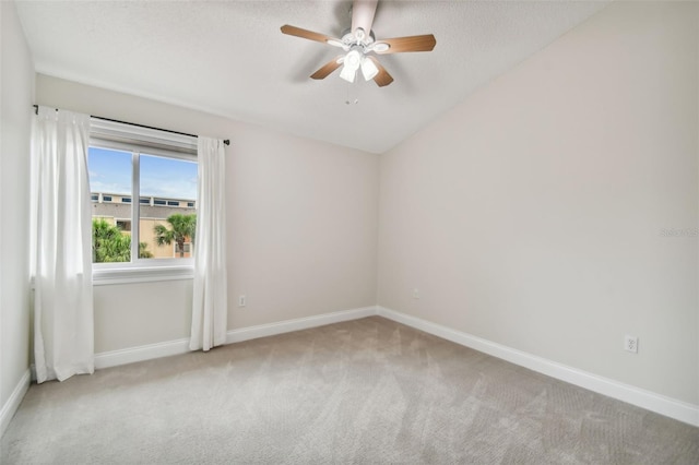 spare room with ceiling fan and light carpet