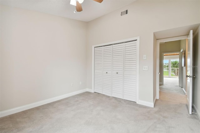 unfurnished bedroom with light carpet, a closet, and ceiling fan