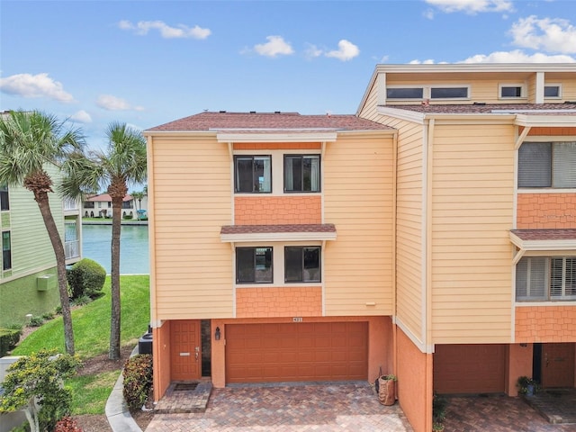 view of front of property with a garage and a water view