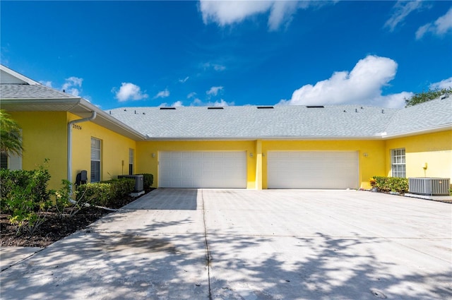 view of side of home featuring cooling unit and a garage