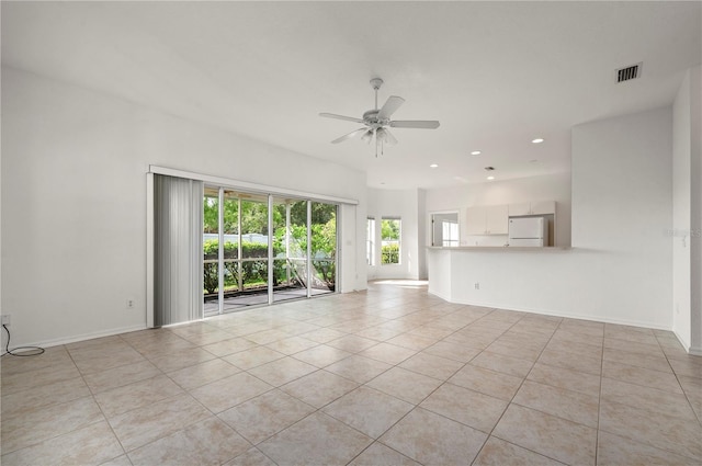 unfurnished living room featuring a wealth of natural light, ceiling fan, and light tile patterned flooring