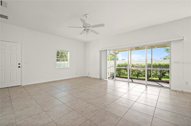 tiled spare room featuring ceiling fan and plenty of natural light