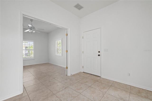 empty room with ceiling fan and light tile patterned flooring