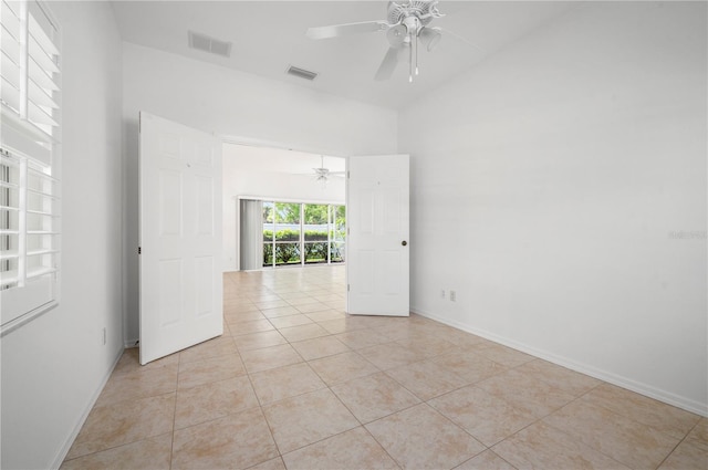 tiled spare room featuring ceiling fan