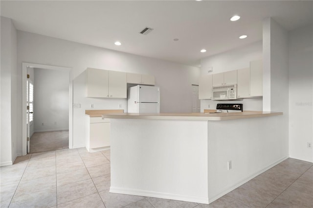 kitchen featuring cream cabinetry, white appliances, kitchen peninsula, and light tile patterned floors