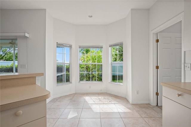 unfurnished dining area featuring light tile patterned floors