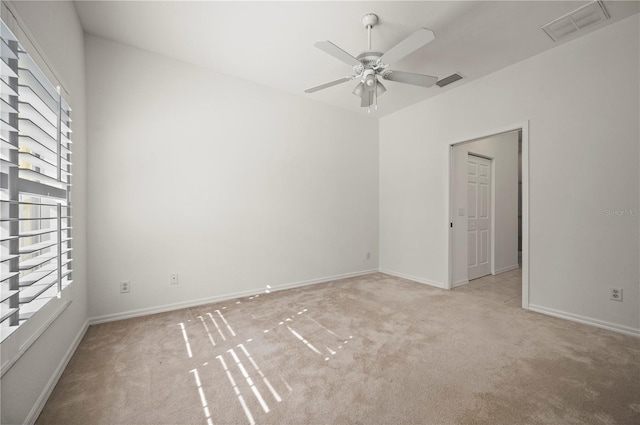 unfurnished room with ceiling fan, a healthy amount of sunlight, and light colored carpet