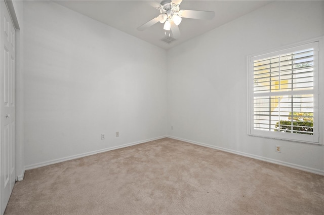 empty room with ceiling fan and light carpet