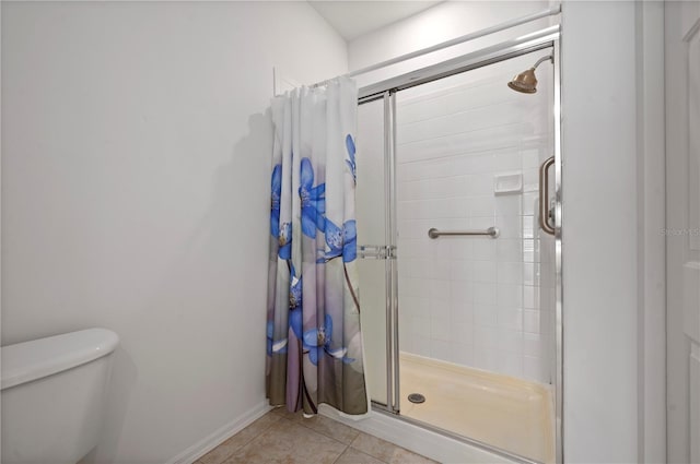 bathroom with tile patterned floors, toilet, and walk in shower