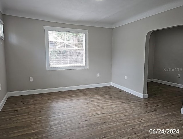 unfurnished room with dark wood-type flooring