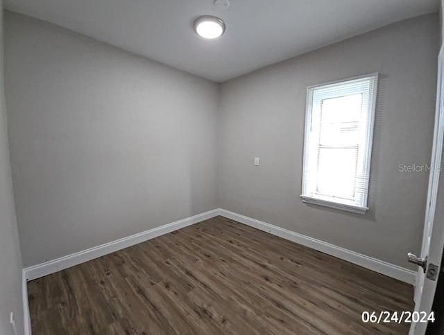 unfurnished room with dark wood-type flooring