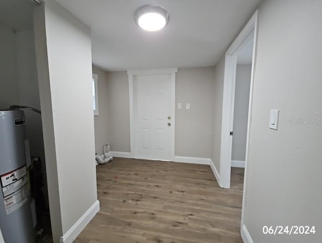 hall with hardwood / wood-style floors and water heater