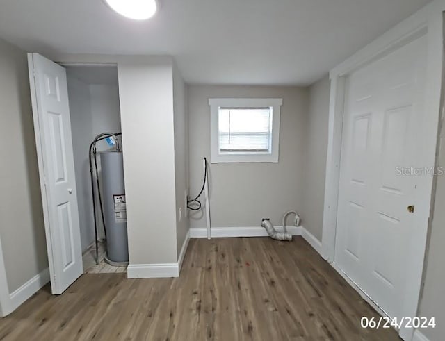 clothes washing area featuring gas water heater and hardwood / wood-style flooring