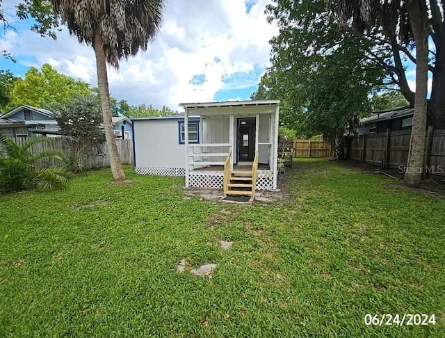 rear view of house featuring a lawn