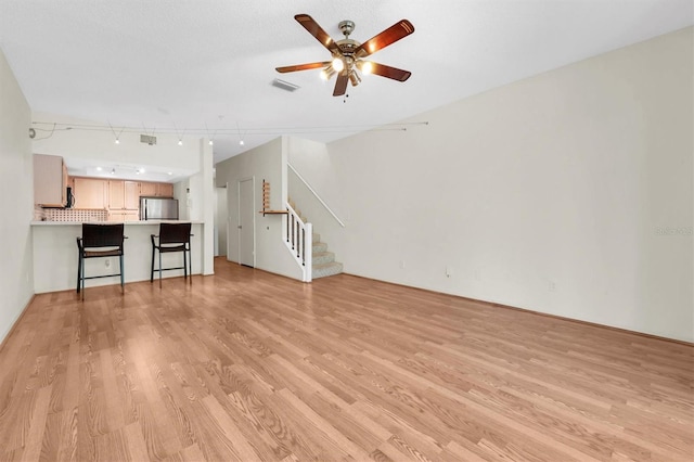 unfurnished living room with light wood-type flooring and ceiling fan