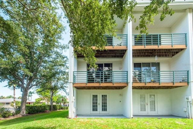 rear view of house featuring a yard, french doors, and a patio