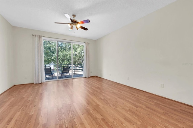 empty room featuring ceiling fan, light hardwood / wood-style floors, and a textured ceiling