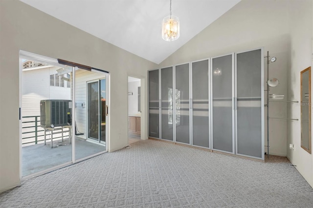 carpeted empty room with high vaulted ceiling