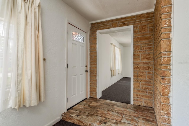 entrance foyer featuring brick wall