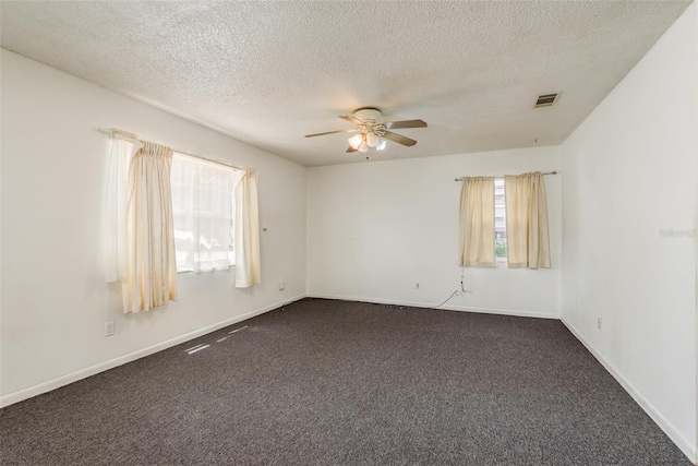 carpeted spare room with a textured ceiling and ceiling fan