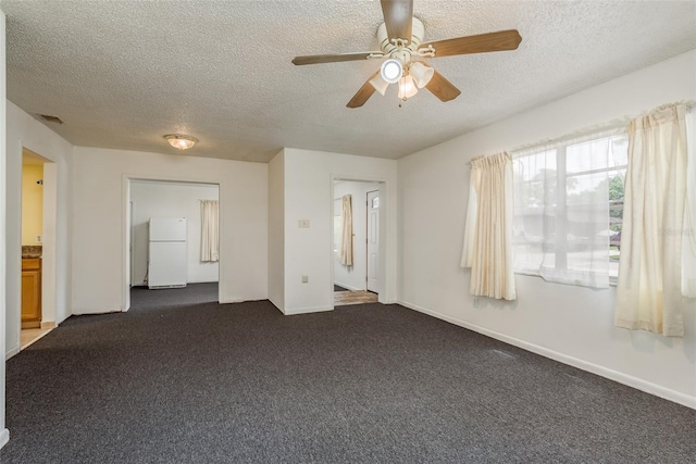 unfurnished bedroom featuring dark colored carpet, ceiling fan, white refrigerator, and a textured ceiling