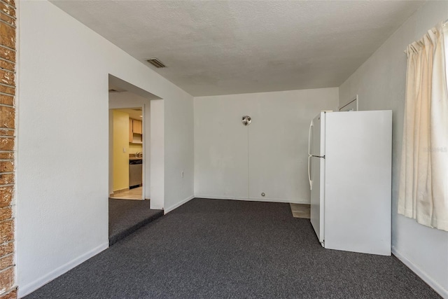 carpeted empty room featuring a textured ceiling